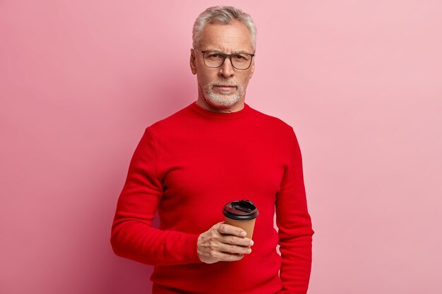 Uomo maggiore che indossa un maglione rosso e occhiali da vista alla moda