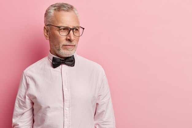 Uomo maggiore che indossa una camicia bianca e papillon nero