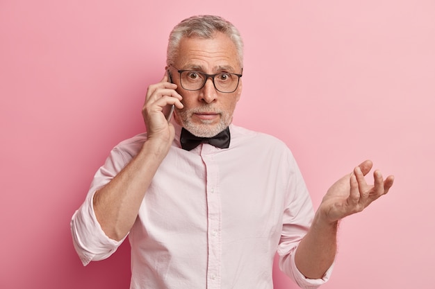 Uomo maggiore che indossa una camicia bianca e papillon nero