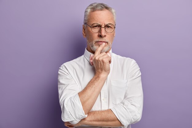 Uomo maggiore che indossa una camicia bianca