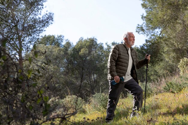 Uomo maggiore del ritratto che fa un'escursione sulla montagna