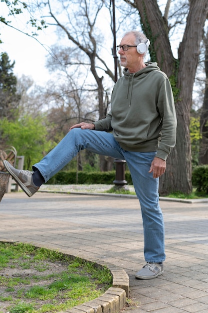 Uomo maggiore moderno che si rilassa nel parco