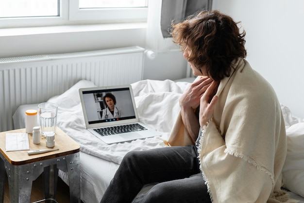 Uomo malato che ha una videochiamata con un medico