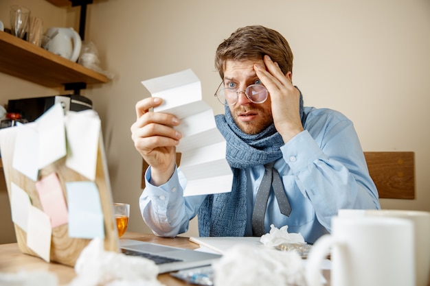 Uomo malato che legge la medicina di prescrizione che lavora in ufficio, uomo d'affari preso raffreddore, influenza stagionale. Influenza pandemica, prevenzione delle malattie, malattia, virus, infezione, temperatura, febbre e influenza