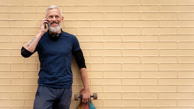 Uomo maturo con skateboard mobilità sostenibile