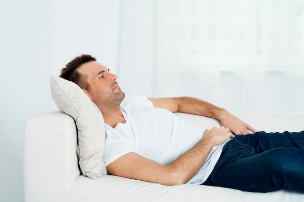 Uomo maturo rilassante sul divano