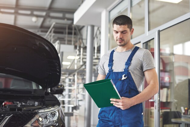 uomo meccanico auto o fabbro con appunti in officina.