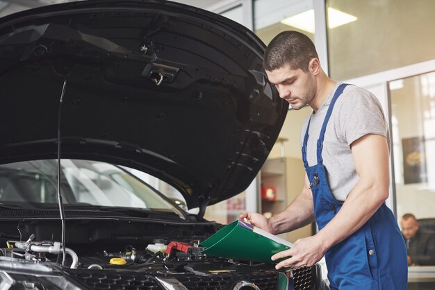 uomo meccanico auto o fabbro con appunti in officina.