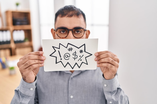 Uomo mediorientale con barba che tiene striscione con parolacce espressione incapace e confusa. concetto di dubbio.