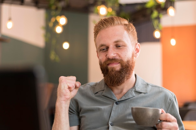 Uomo moderno bello che tiene una tazza di caffè