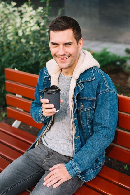 Uomo moderno che si siede sulla panchina in ambiente urbano