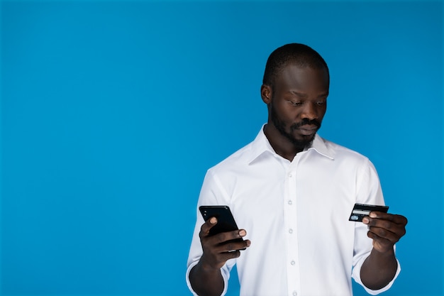 Uomo moderno che usando una carta di credito con un telefono