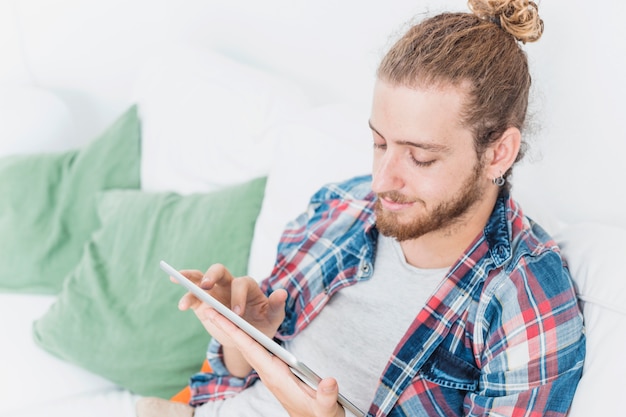 Uomo moderno che utilizza la tabella sul divano