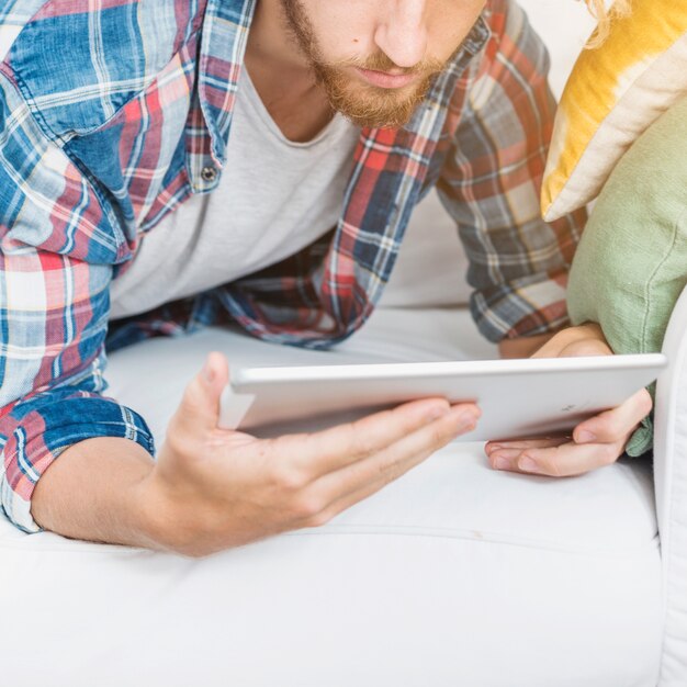 Uomo moderno che utilizza la tabella sul divano