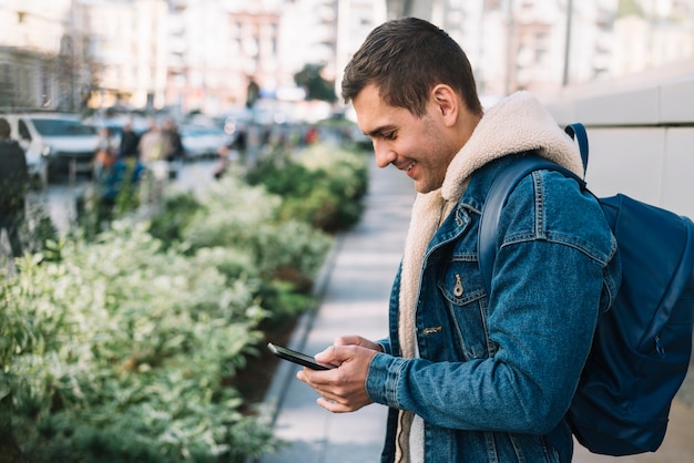 Uomo moderno che utilizza smartphone in città