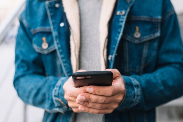 Uomo moderno che utilizza smartphone in città