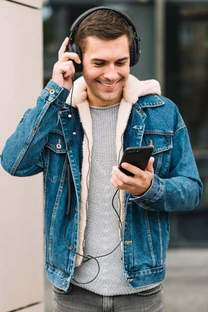 Uomo moderno con le cuffie in ambiente urbano