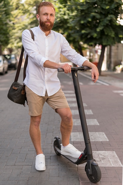 Uomo moderno di vista frontale su scooter all'esterno