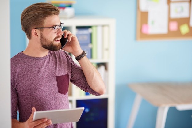 Uomo multi-tasking nel suo ufficio a casa