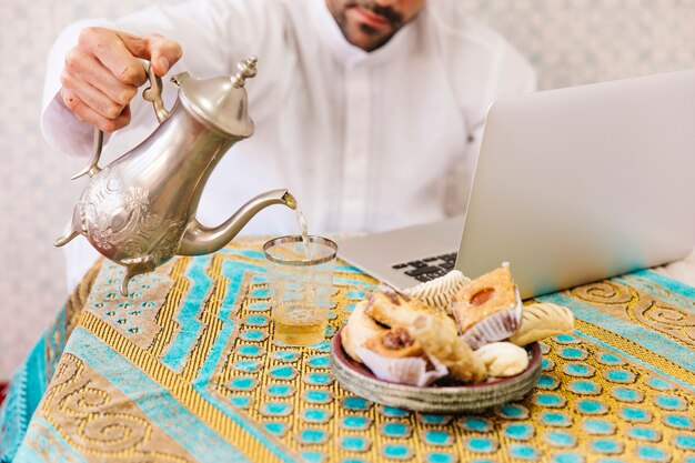 Uomo musulmano con cibo e laptop