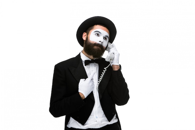 Uomo nel mime di immagine che tiene un microtelefono.