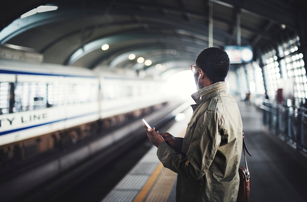 Uomo nero in attesa di un treno sulla piattaforma