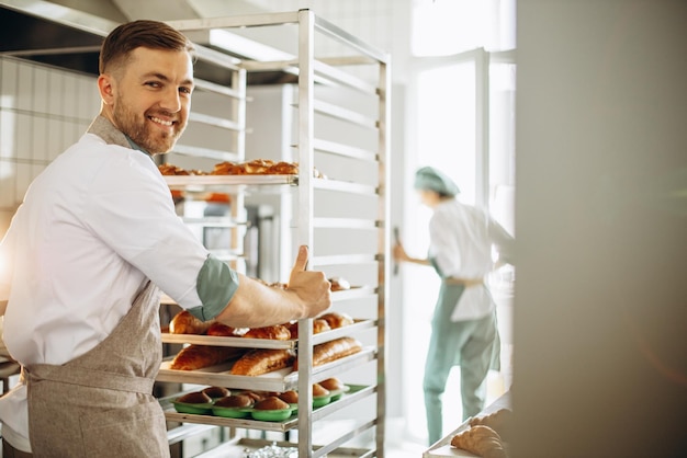 Uomo panettiere in cucina dal carrello della pasticceria