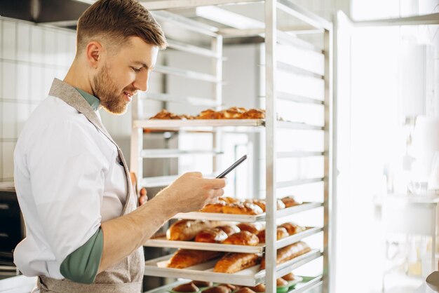 Uomo panettiere in cucina tramite telefono