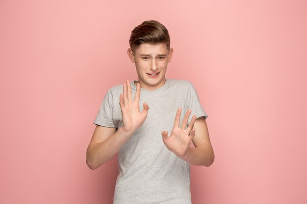 Uomo pensieroso dubbioso con espressione pensosa fare una scelta contro il muro rosa