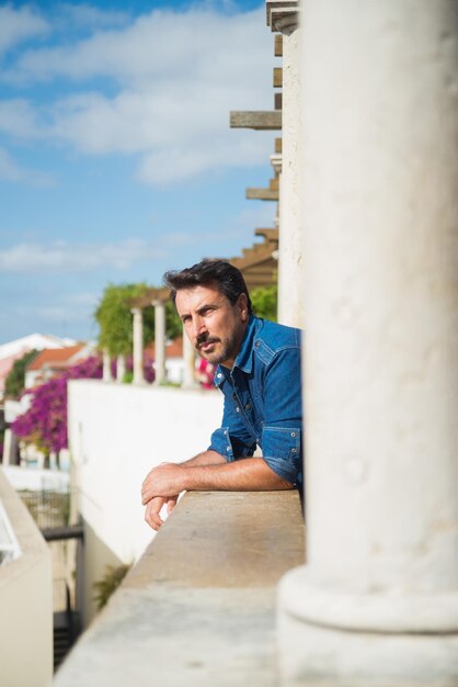 Uomo pensieroso in piedi sul balcone