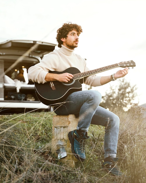 Uomo pieno del colpo che gioca la chitarra