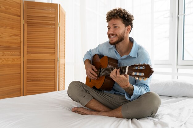 Uomo pieno del colpo che gioca la chitarra