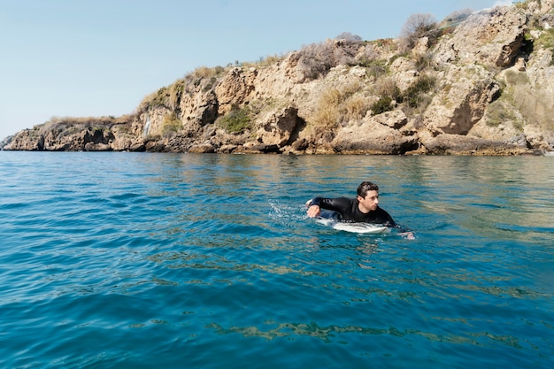 Uomo pieno del colpo che pratica il surfing con il bordo