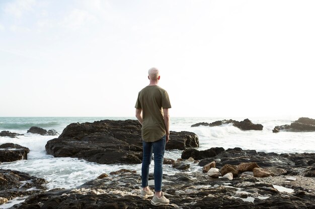 Uomo pieno del colpo che sta sulle rocce