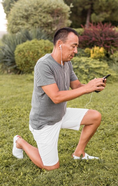 Uomo pieno del colpo che tiene smartphone