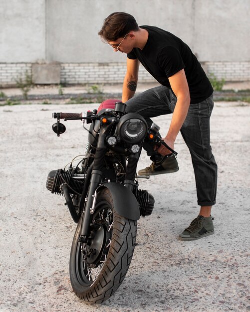 Uomo pieno del colpo con la vecchia motocicletta