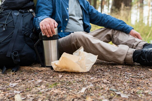 Uomo più anziano che riposa mentre viaggia all'aperto