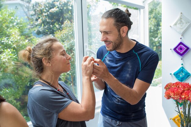 Uomo positivo e donna che chiacchierano nella cucina