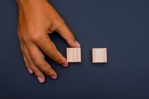 uomo posizionando cubi di legno.