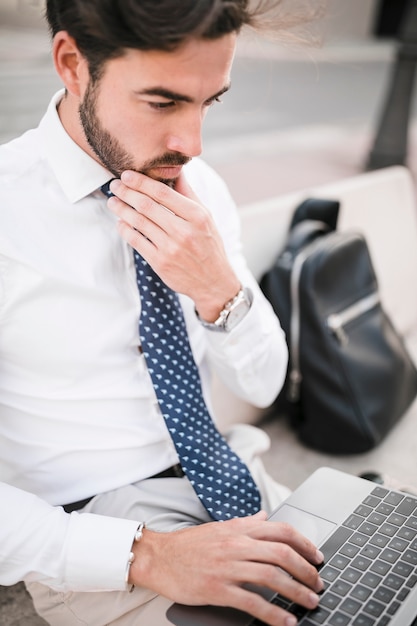 Uomo premuroso che lavora al computer portatile