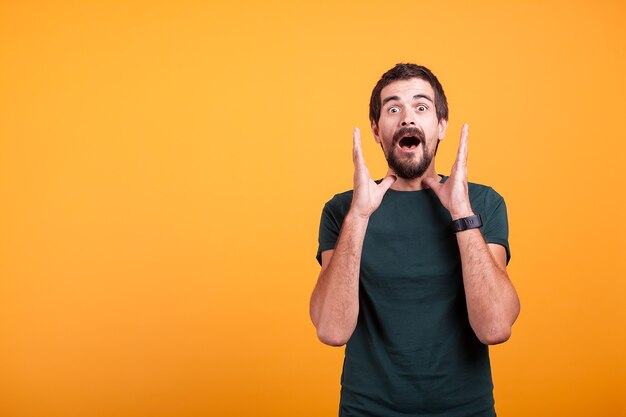 Uomo scioccato con le mani in faccia guardando la telecamera. Copyspace disponibile per la tua pubblicità o promo