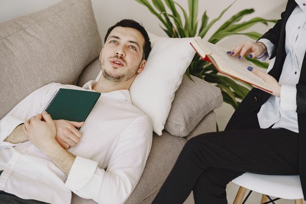 Uomo seduto nell'ufficio dello psicologo e parlando di problemi