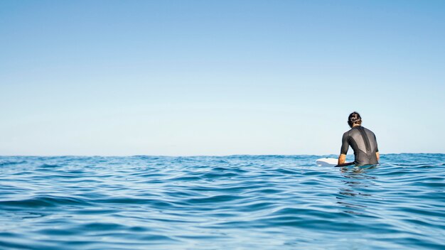 Uomo seduto nello spazio della copia dell'acqua