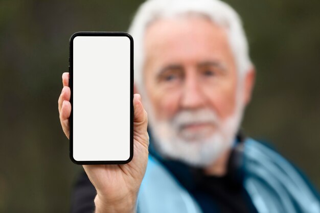 Uomo senior del ritratto che pareggia sulla montagna