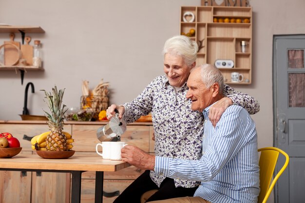 Uomo senior e donna che mangiano caffè