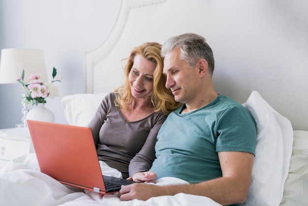 Uomo senior e donna insieme a letto