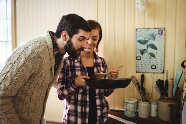 Uomo sentente l'odore di cibo preparato da donna