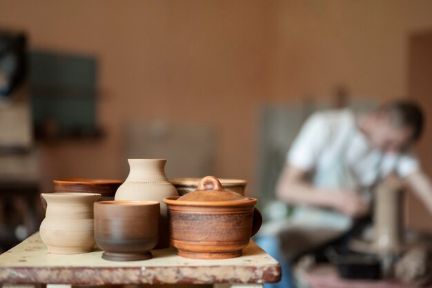 Uomo sfocato del colpo medio che fa ceramica