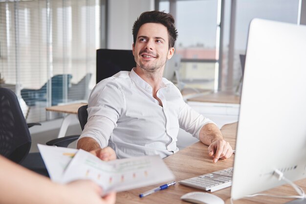 Uomo sicuro che lavora alla sua postazione di lavoro