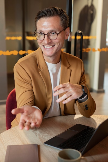 Uomo sorridente a tiro medio al lavoro